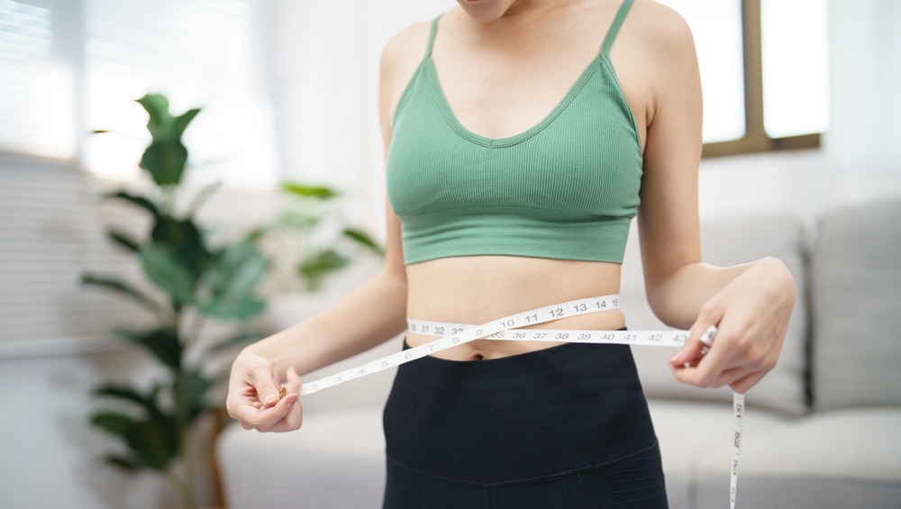 woman measuring waist with measure tape