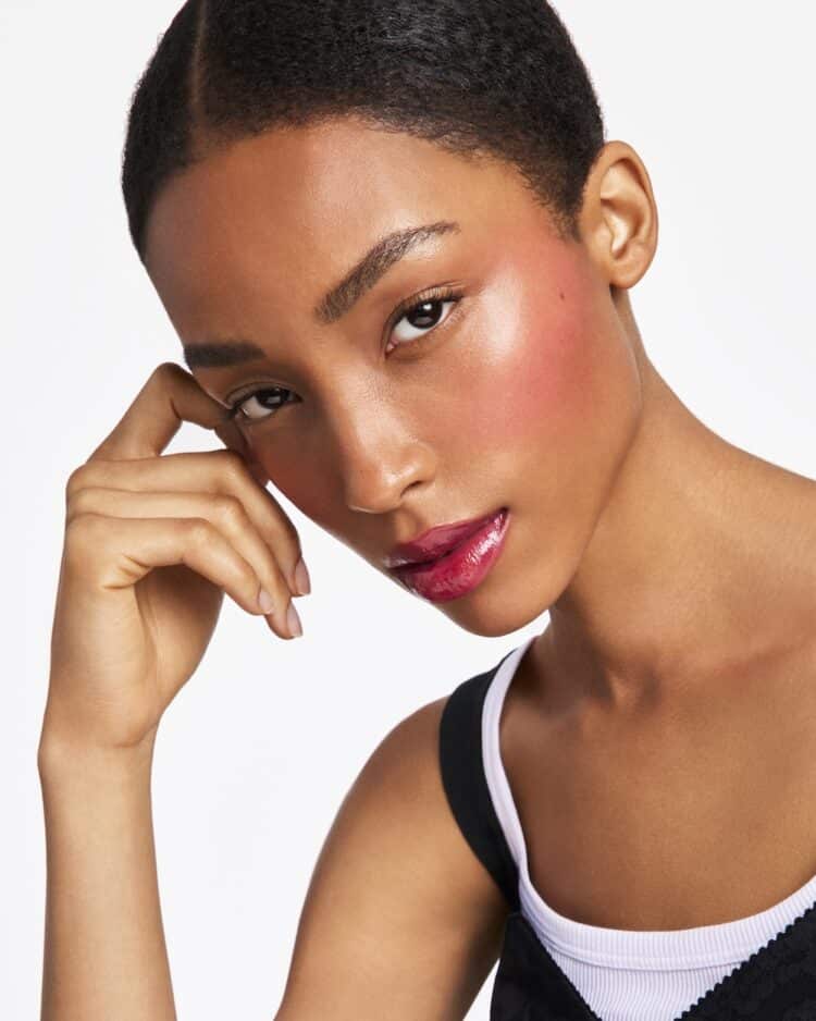 Model wearing Rose Dew Lip Bite in Flirty Red, $65
